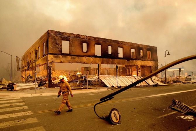 El jefe de operaciones Jay Walter pasa por el histórico edificio Sierra Lodge mientras el incendio Dixie arde en Greenville, California, el 4 de agosto. El incendio arrasó con varios edificios históricos y docenas de casas en el centro de Greenville. Foto de Noah Berger / AP