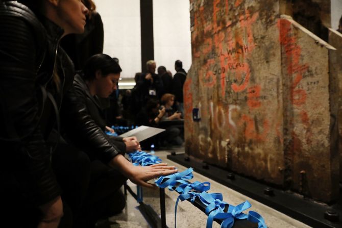 La gente ata cintas azules frente al último pilar de las Torres Gemelas que quedó en pie tras los atentados del 11 de septiembre de 2001. La imagen es del 30 de mayo de 2017.