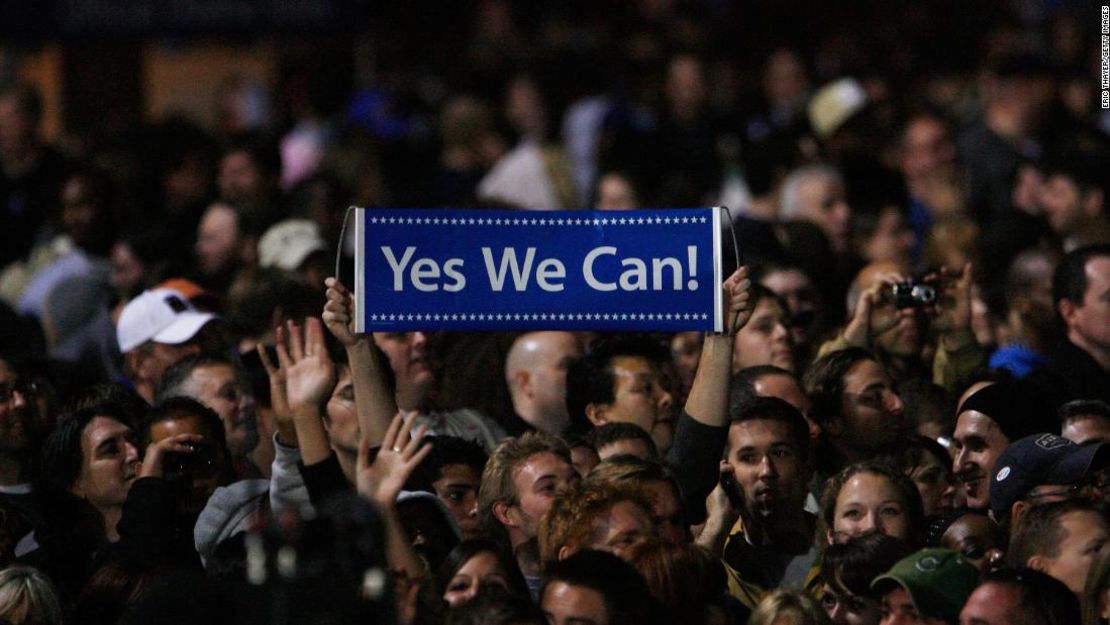 Un simpatizante sostiene un cartel en el que se lee "Yes we can" mientras el presidente electo Barack Obama pronuncia su discurso de victoria la noche de las elecciones, el 4 de noviembre de 2008, en el Grant Park de Chicago.