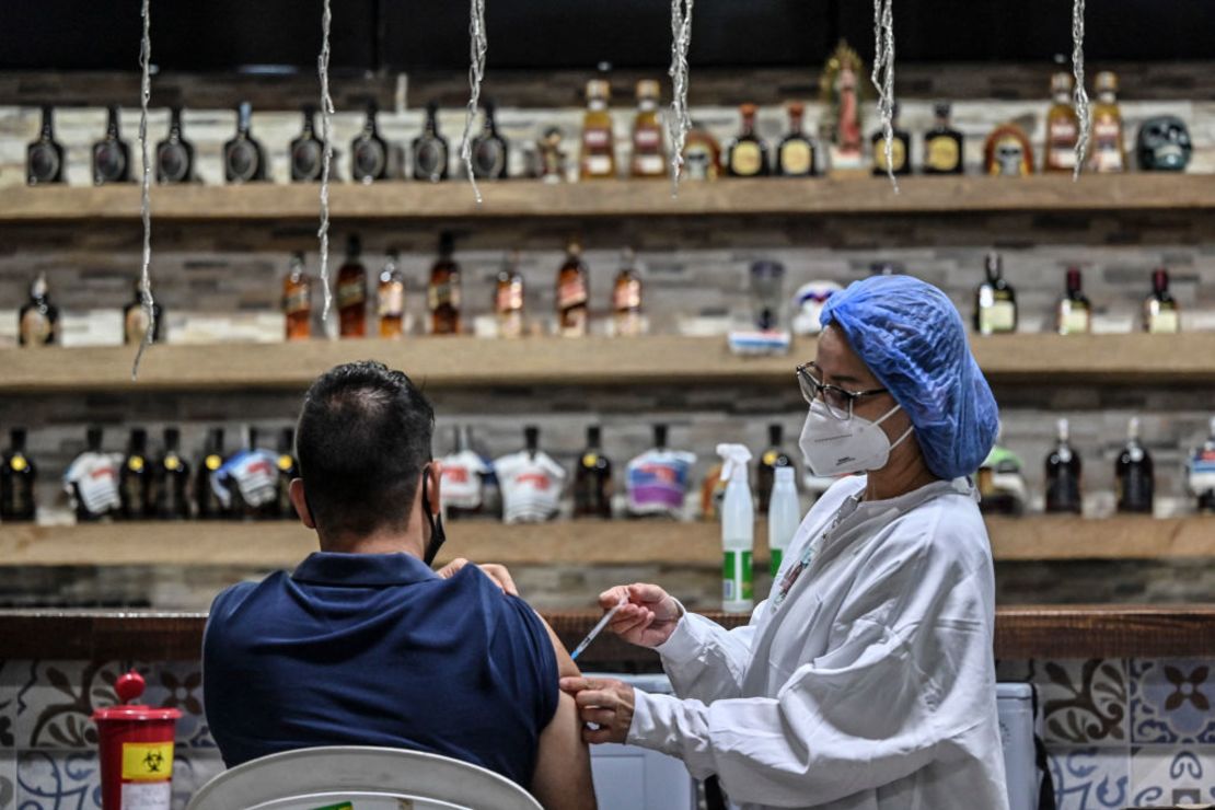 Una enfermera aplica una dosis de la vacuna de Moderna en el bar La Cantina en Medellín el 11 de agosto de 2021. Las personas mayores de 18 años que trabajan en el sector gastronómico están siendo vacunadas como parte de un programa patrocinado por el sector privado en Colombia.