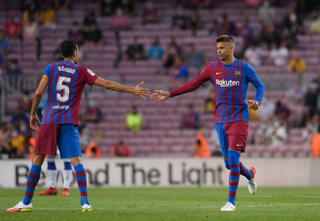 Gerard Piqué celebra con Sergio Busquets después de anotar durante el partido de fútbol de la Liga española entre el Barcelona y la Real Sociedad en el estadio Camp Nou de Barcelona el 15 de agosto de 2021.