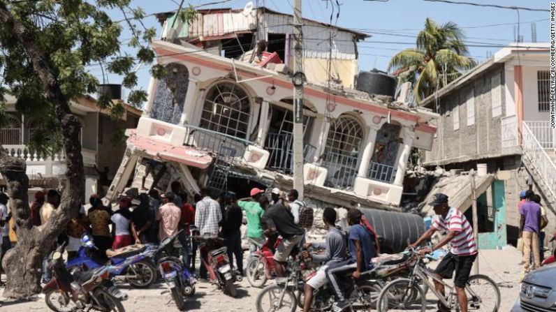 Los residentes inspeccionan un edificio dañado tras un terremoto de magnitud 7,2 en Les Cayes, Haití, el domingo 15 de agosto de 2021. Estados Unidos desplegó equipos de búsqueda y rescate para ayudar a encontrar sobrevivientes entre los escombros de edificios derrumbados en Haití a medida que aumenta el número de muertos. del terremoto masivo del sábado. Mira en esta galería las fotos de la devastación del terremoto en Haití.