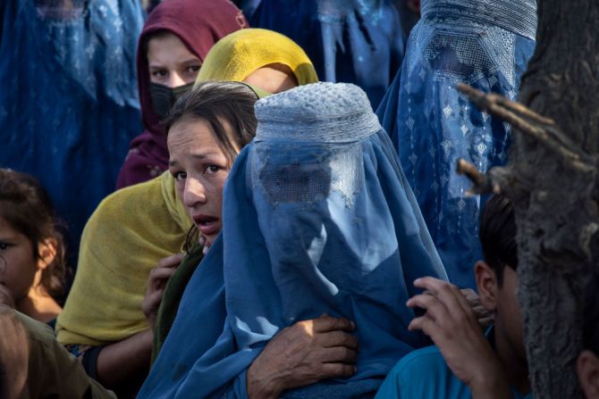 Ciudadanos desplazados esperan a la entrada de un campamento, tras huir desesperadamente abandonando sus hogares ante el avance talibán.