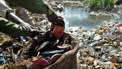 Two Kenyan men gathering discarded flip-flops and other rubber waste near Africa's largest slum Kibera for recycling, outside Nairobi on May 2, 2009. An ingenious method to contain rubber waste has been to gather old flip-flops and other rubber waste and use it to make art by a Kenyan cottage industry called 'Unique Eco' has yielded the double benefit of creating employment for thousands of indigenous women and young people in both urban and remote villages as well as avert, in measure, massive pollution. Recycling is arguably an-all-round solution to the multiplication of problems faced especially by developing countries as it reduces global-warming and over-dependence on increasingly stretched natural resources by an ever increasing global population and create employment opportunities. AFP PHOTO/Tony KARUMBA