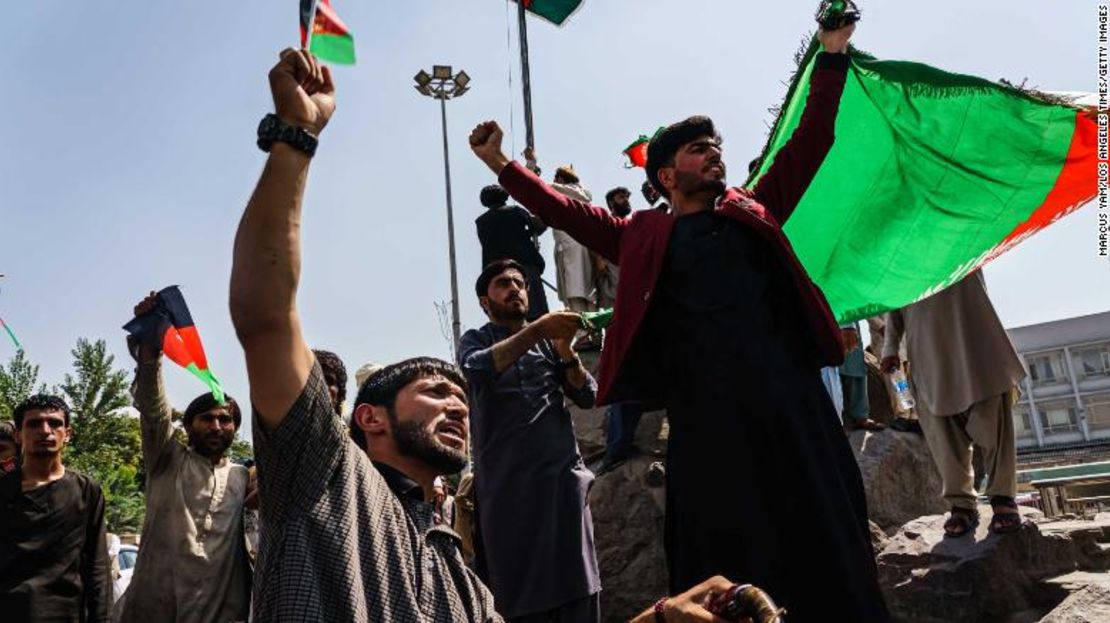 Afganos enarbolan la bandera nacional en Kabul el jueves, a pesar de la presencia de combatientes talibanes.