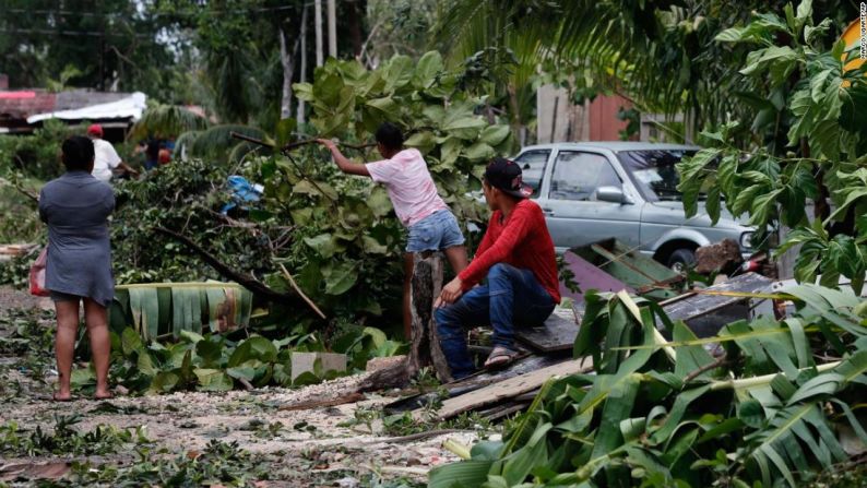 Residentes locales retiran ramas y escombros que dejó el paso del huracán Grace en Tulum, México, el 19 de agosto de 2021.