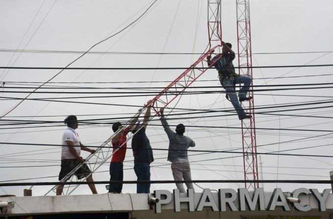 Trabajadores reparan una antena de comunicaciones que fue afectada por el paso del huracán Grace, en Quintana Roo.