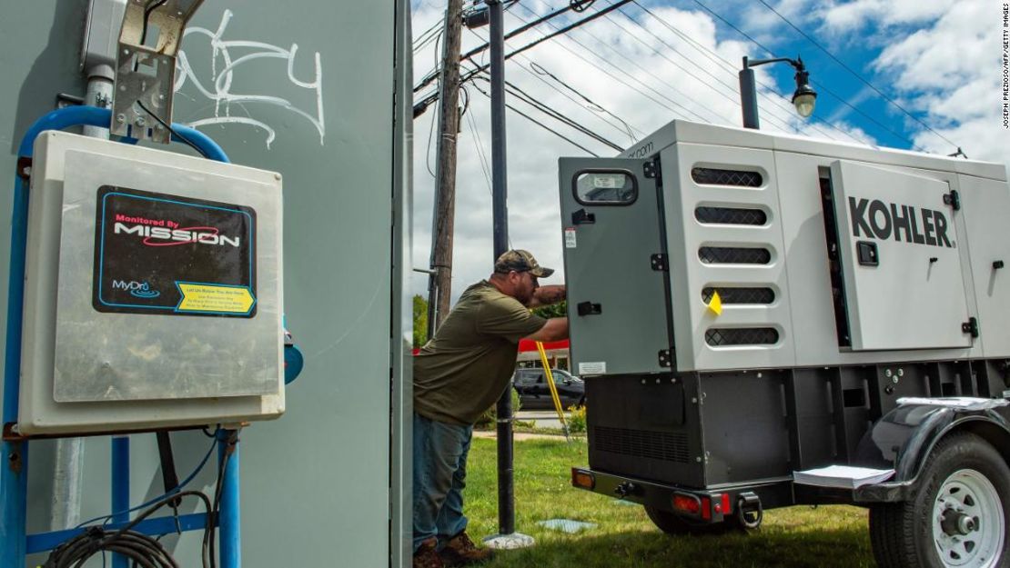 Un empleado de la ciudad en Bourne, Massachusetts, conecta un generador a una bomba de aguas residuales en el caso de una pérdida eléctrica cuando Henri se acercaba el viernes.