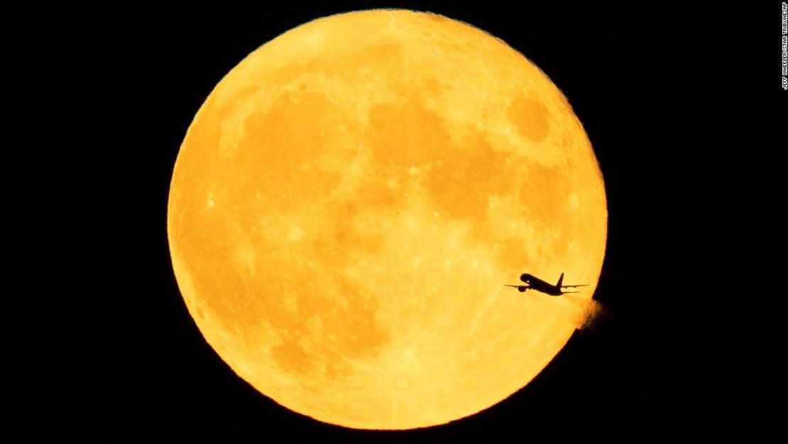 Un avión pasa frente a una luna Sturgeon (luna azul) después del despegue desde el aeropuerto internacional de Minneapolis-St. Paul el 3 de agosto de 2020.