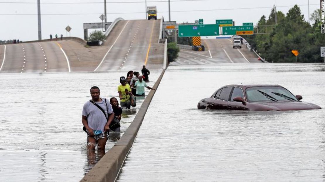 Los evacuados pasan por una sección sumergida de la Interestatal 610 en Houston después de que el huracán Harvey en 2017 causara inundaciones generalizadas.