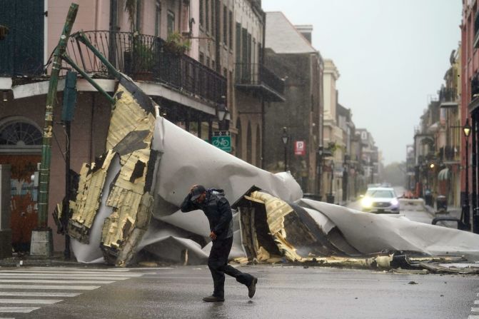 Un hombre pasa por una sección del techo que voló de un edificio en el Barrio Francés de Nueva Orleans el domingo. Eric Gay / AP