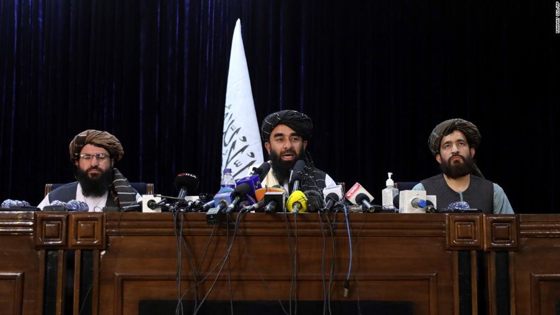 El portavoz talibán, Zabihullah Mujahid, en el centro, habla en su primera conferencia de prensa en el Centro de Información de Medios del Gobierno, en Kabul, Afganistán, el martes 17 de agosto de 2021.