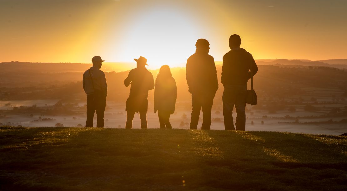 La gente ve el sol de otoño desde Glastonbury Tor cerca de Glastonbury el 22 de septiembre de 2017 en Somerset, Inglaterra.