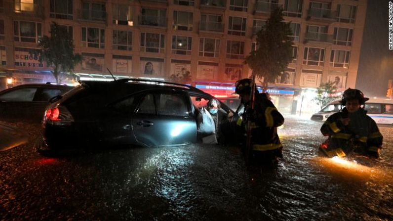 Miembros del Departamento de Bomberos de Nueva York rescatan a una mujer de su automóvil parado en medio de una inundación repentina en Nueva York el miércoles por la noche, 1 de septiembre de 2021. Anthony Behar / Sipa / AP