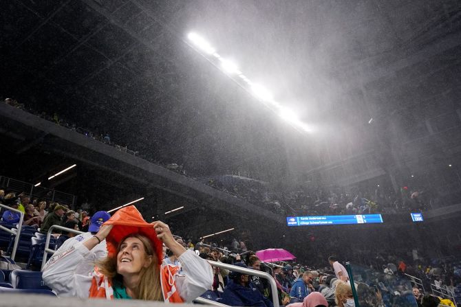 Una fan se cubre de la lluvia dentro del estadio techado Louis Armstrong, durante un partido en el campeonato de tenis del US Open en Nueva York. Frank Franklin II / AP