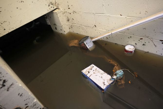 Una caja de mascarillas se ve flotando en el sótano inundado de una casa en la calle Lester, en la ciudad de Passaic, Nueva Jersey.