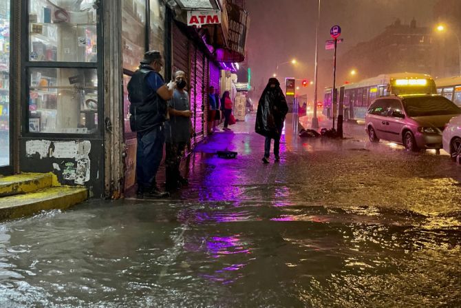 La gente se abre camino entre las calles inundadas por los remanentes de Ida en el Bronx, en Nueva York.