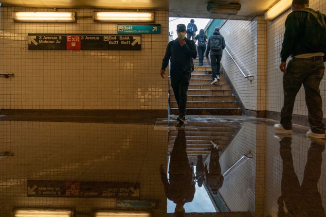 Pasajeros ingresan a una estación de metro inundada por los remanentes del huracán Ida en el Bronx, en Nueva York.