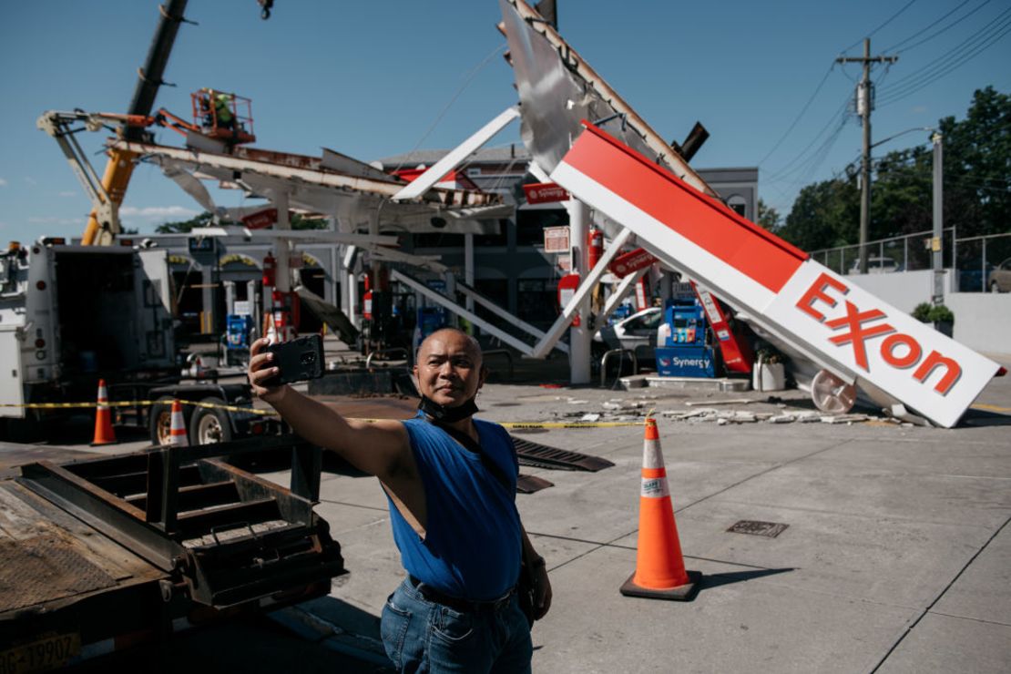 Un hombre se toma una selfie en una estación de gasolina devastada por las lluvias torrenciales y los fuertes vientos en Queens.