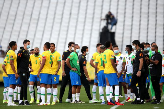 Jugadores de Brasil hablan mientras el partido es retrasado por las autoridades sanitarias durante un partido entre Brasil y Argentina.