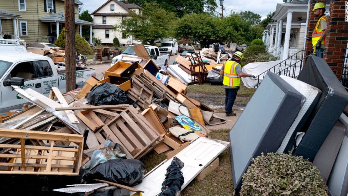 Trabajadores de servicios públicos trabajan entre los escombros de los daños causados por las inundaciones causadas por los restos del huracán Ida en Manville, Nueva Jersey, el domingo.