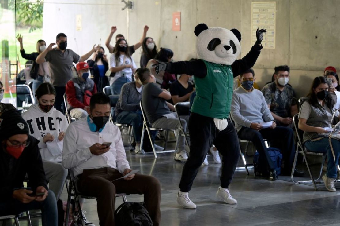 Un empleado del gobierno local disfrazado de panda llamado "Pandemio" realiza una rutina de ejercicios para personas que ya recibieron la vacuna contra covid-19 en la Ciudad de México.