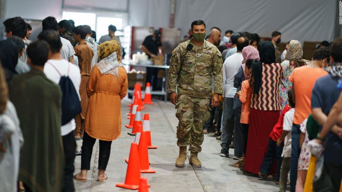 Refugiados afganos hacen cola para recibir comida en un comedor de la Aldea Doña Ana de Fort Bliss, donde están siendo alojados en Chaparral, Nuevo México, el viernes 10 de septiembre de 2021.