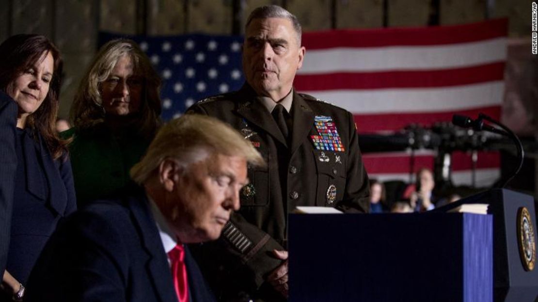 El presidente del Estado Mayor Conjunto, el general Mark Milley, arriba en el centro, observa cómo el presidente Donald Trump firma la Ley de Autorización de Defensa Nacional para el Año Fiscal 2020 en la Base de la Fuerza Aérea Andrews, Maryland, en diciembre de 2019.