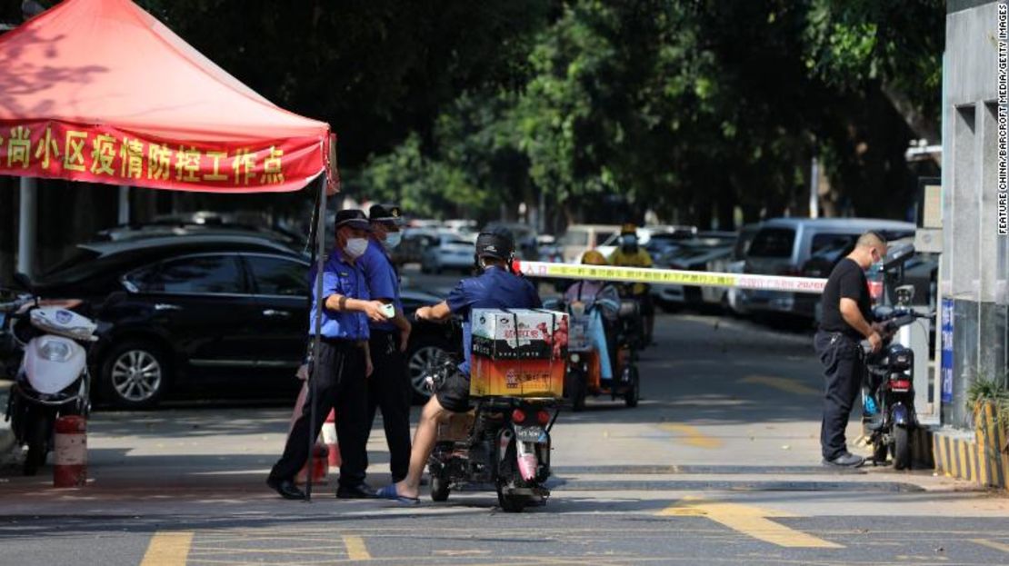 Trabajadores del gobierno detienen a un motociclista en la entrada de un bloque de viviendas en cuarentena en Xiamen, en la provincia de Fujian, al sureste de China, el 14 de septiembre.