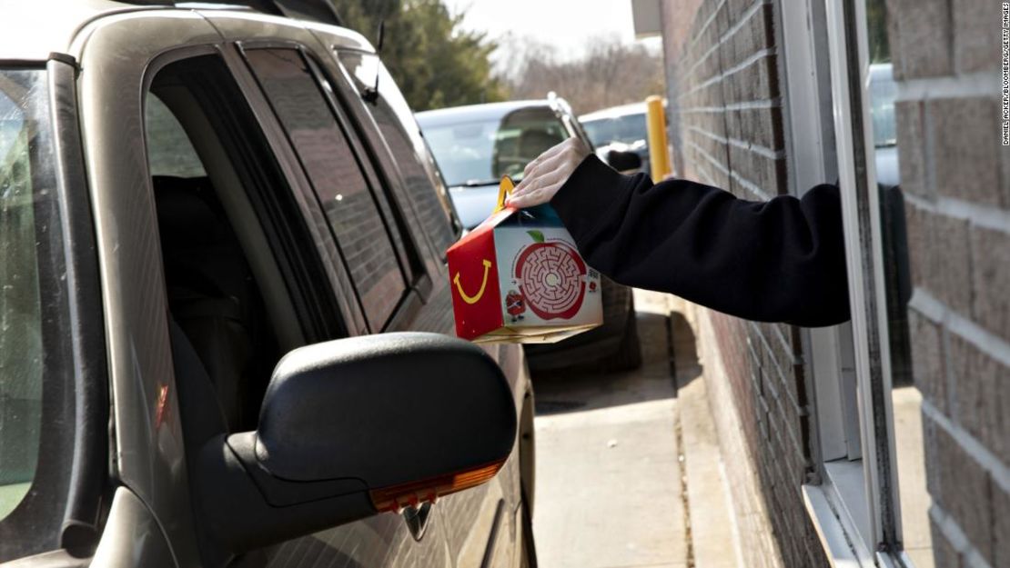 Un empleado entrega una Cajita Feliz en un McDonald's