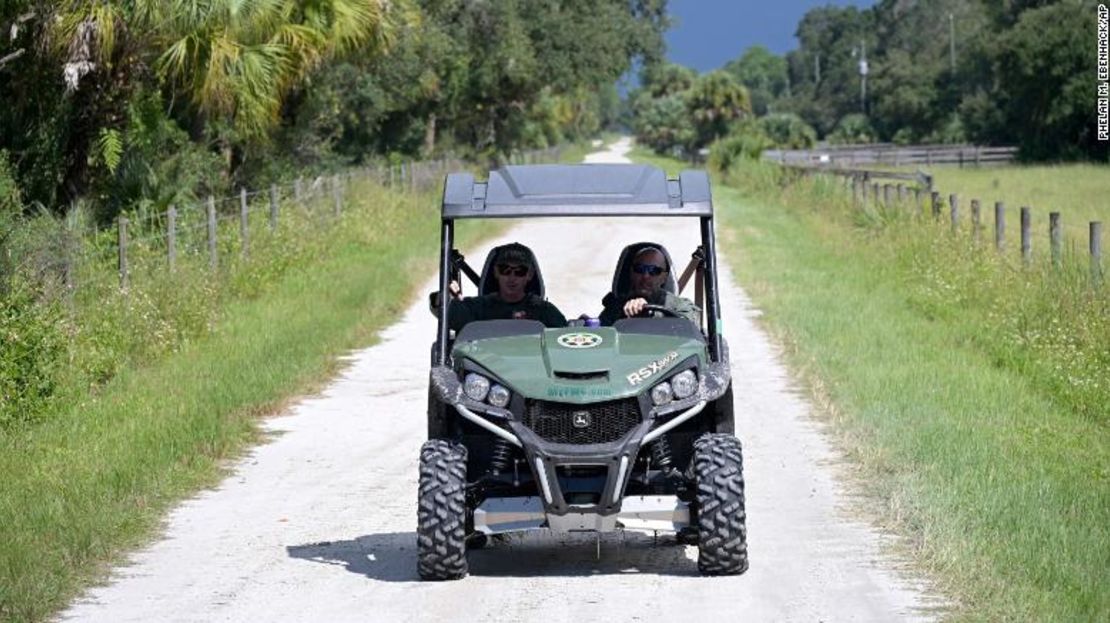 Los oficiales de la Comisión de Pesca y Vida Silvestre de Florida suben por un camino privado cerca de la entrada de la Reserva Carlton durante la búsqueda de Brian Laundrie el martes 21 de septiembre.