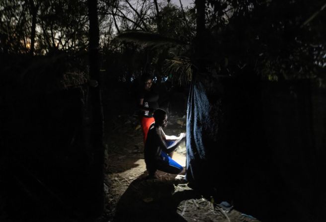 Migrantes trabajan en su vivienda temporal en el campamento.