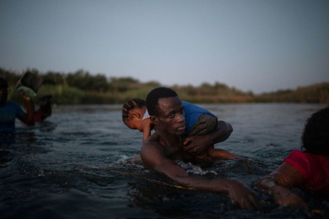 Migrantes cruzan el río Bravo el 19 de septiembre. Las escenas han provocado la ira de los funcionarios locales y federales. Algunos han calificado el campamento improvisado de inhumano.