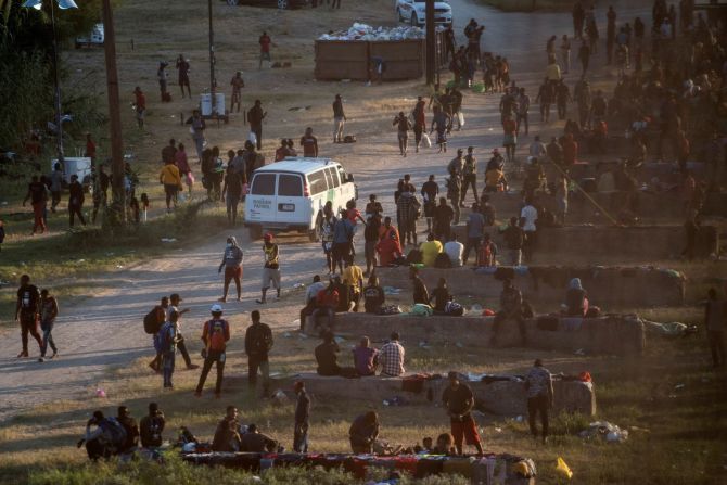 Migrantes se reúnen cerca del puente mientras esperan ser procesados en Del Río el 16 de septiembre.