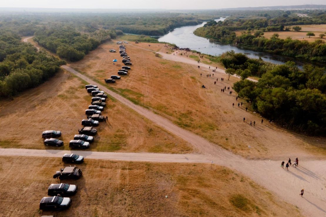 Vehículos alineados a lo largo de las orillas del Río Grande, cerca del campamento de Del Rio, el 21 de septiembre. El gobernador de Texas Greg Abbott dijo que las autoridades utilizan métodos "sin precedentes" para disuadir a los migrantes de cruzar al estado, incluyendo estacionar los vehículos de la Guardia Nacional de Texas y del Departamento de Seguridad Pública de Texas a lo largo de la frontera para crear una "barrera de acero". Créditos: Julio Cortez/AP