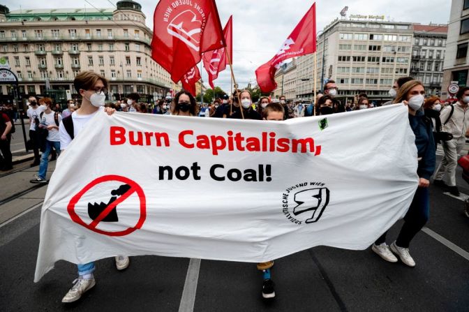 Participantes sostienen una pancarta en la que se lee "Quema el capitalismo, no el carbón" durante la manifestación en Viena, Austria.