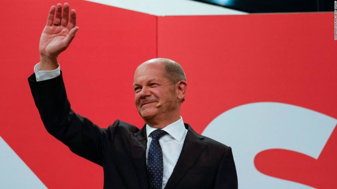 Olaf Scholz saluda a la sede del SPD después de que las estimaciones fueran transmitidas por televisión, en Berlín.