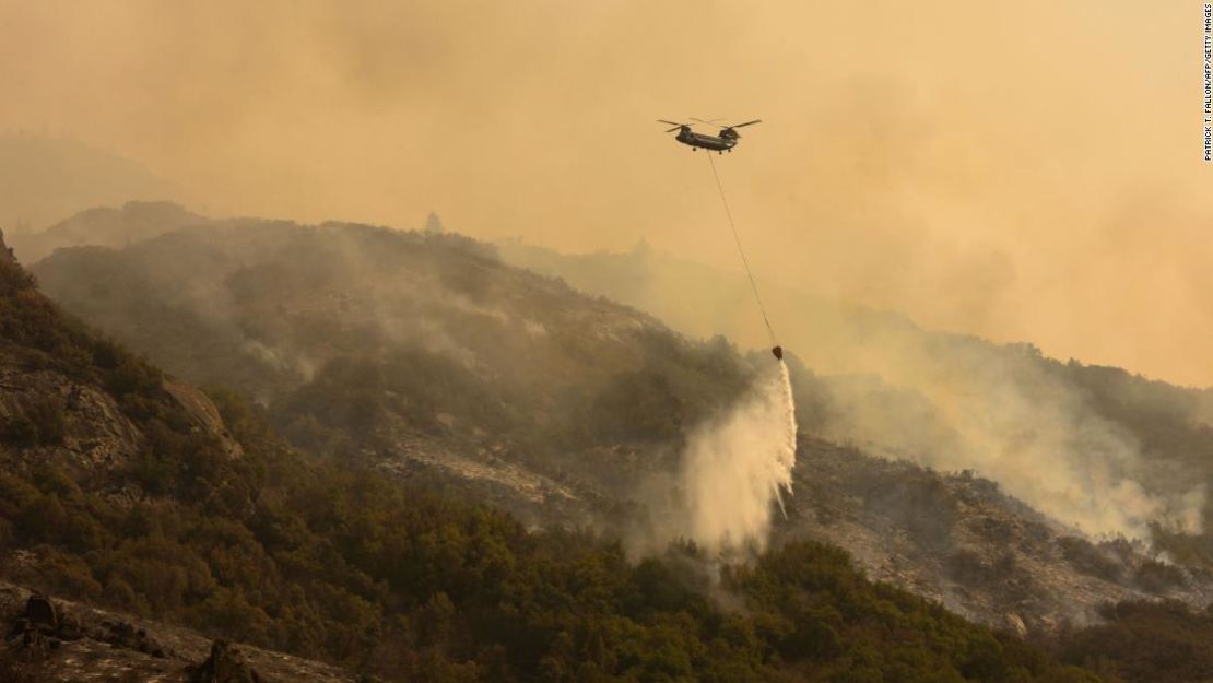 Un helicóptero de extinción de incendios Chinook transporta agua para arrojarla sobre el incendio del KNP Complex en el Parque Nacional de Sequoia, que sigue causando estragos.