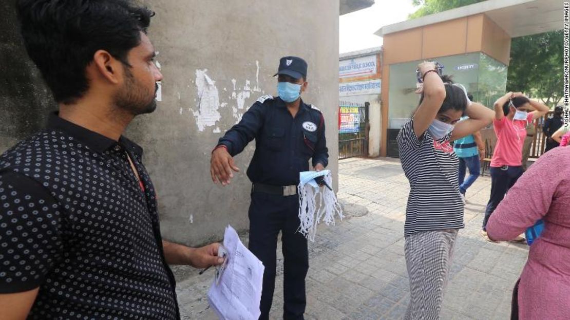 Los examinados reciben mascarillas desechables nuevas mientras se preparan para realizar el Examen de Elegibilidad para Profesores de Rajastán (REET) en un centro de examen en Jaipur, India, el 26 de septiembre.