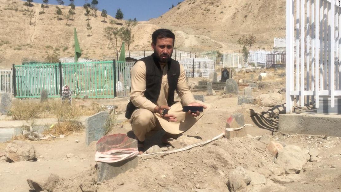 Emal Ahmadi, que perdió a 10 familiares en un ataque con drones, les guarda luto en una tumba en Kabul.