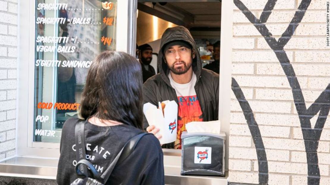 Eminem sirve a un fan en la noche de apertura de su restaurante Mom's Spaghetti en Detroit.