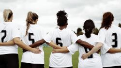 Female soccer players huddling and standing together