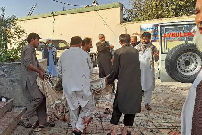 Hombres afganos llevan el cadáver de una víctima a una ambulancia después de un ataque con bomba en una mezquita en Kunduz el 8 de octubre de 2021.