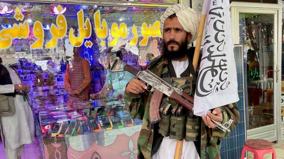 Un combatiente talibán espera fuera de una tienda de electrónica en Ghazni.