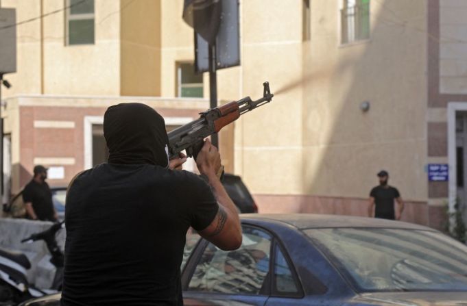 Un combatiente chiita de los movimientos Hezbollah y Amal apunta con un fusil de asalto Kalashnikov en medio de enfrentamientos en la zona de Tayouneh, en el suburbio del sur de Beirut. Mira a continuación las imágenes del tiroteo que sacudió al Líbano.