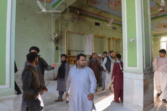 Hombres afganos caminan dentro de la mezquita chiita en Kandahar, después de un ataque suicida con bomba durante las oraciones del viernes que mató a más de 30 personas.