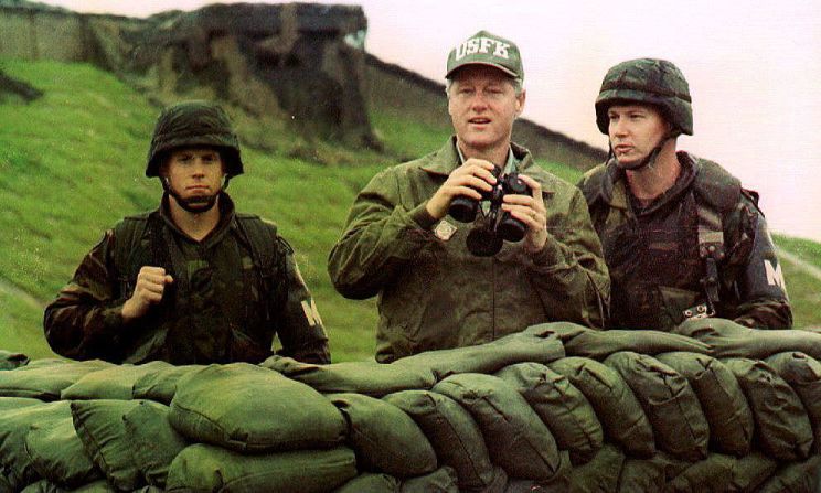 Clinton usa binoculares para mirar a través de la Zona Desmilitarizada hacia Corea del Norte el 11 de julio de 1993 con dos soldados estadounidenses.