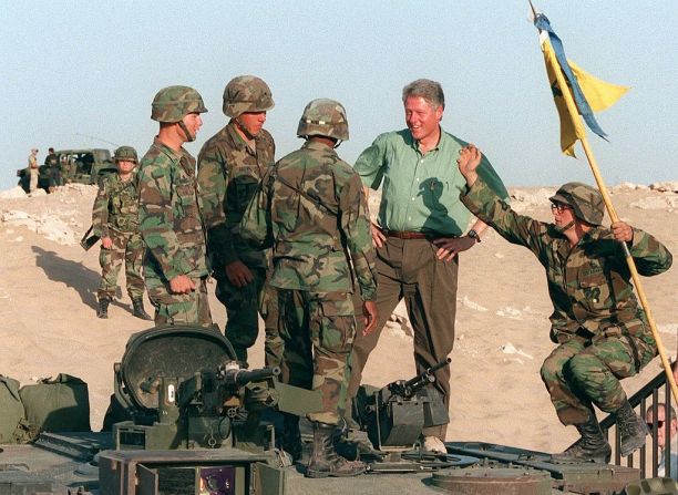 El presidente estadounidense Bill Clinton en una foto tomada el 28 de octubre de 1994 en Liberty Bridge en Kuwait, a unos 50 km de la frontera iraquí, conversa con tropas estadounidenses en la parte superior de un tanque M-1.
