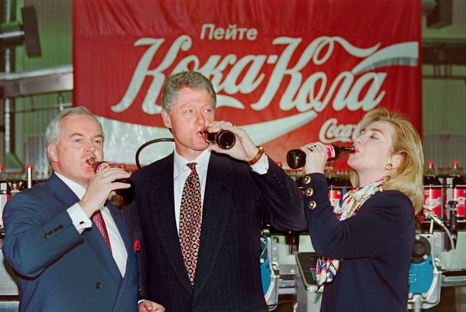 El presidente estadounidense Bill Clinton, la primera dama Hillary Rodham Clinton y Michael O'Neill, Subgerente Regional de Coca-Cola en Rusia, beben una Coca-Cola el 11 de mayo de 1995, en Moscú, durante su visita a la Coca. -Fábrica de Cola en la capital rusa.