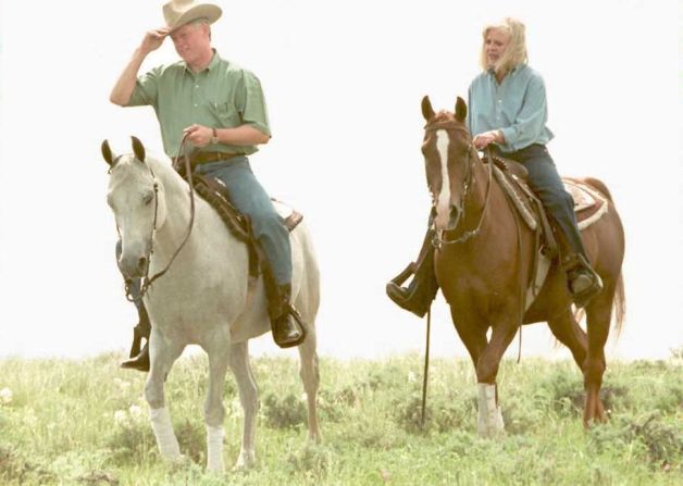 El presidente estadounidense Bill Clinton Se sienta en el caballo árabe Phire Power mientras cabalga con la propietaria del Centro Ecuestre Intermountain, Joan Scott,.